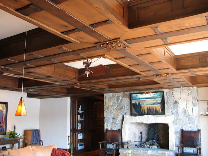 Custom beamed wood ceiling above a stone fireplace