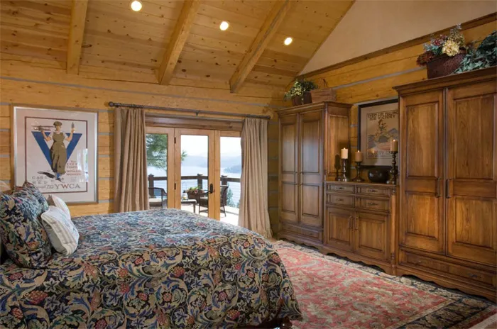 Master bedroom wall of custom built-in wardrobes under a vaulted wood ceiling