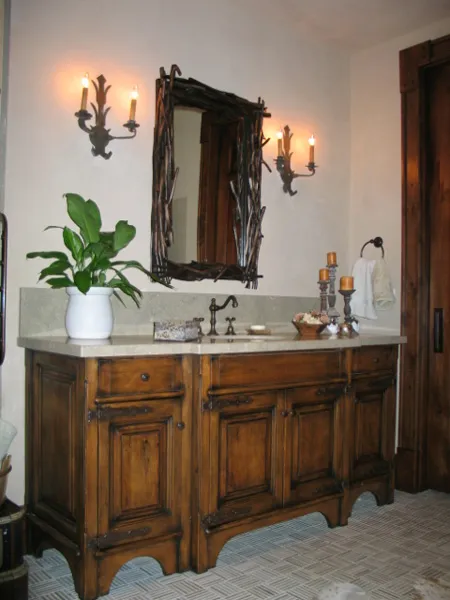 Rustic vanity with a branch-framed mirror and marble top