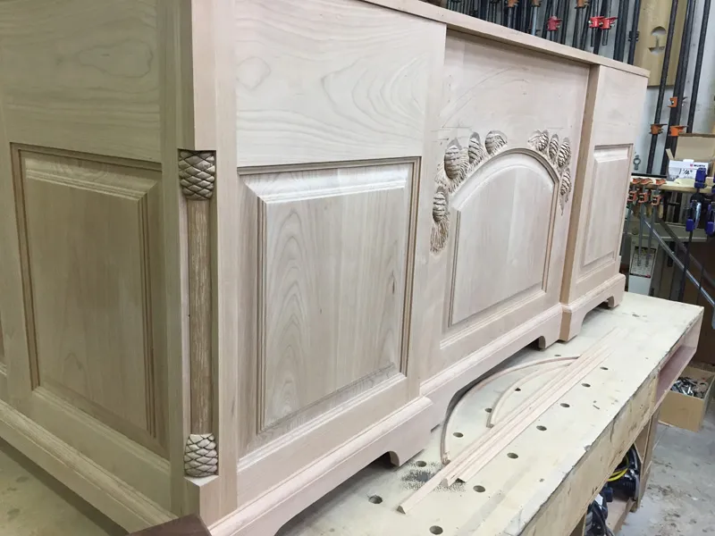 Close-up of a hand-carved white-oak panel taking shape in The Joinery workshop