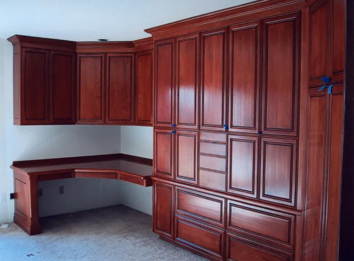 Cherry raised-panel built-in wall unit with a corner desk by The Joinery