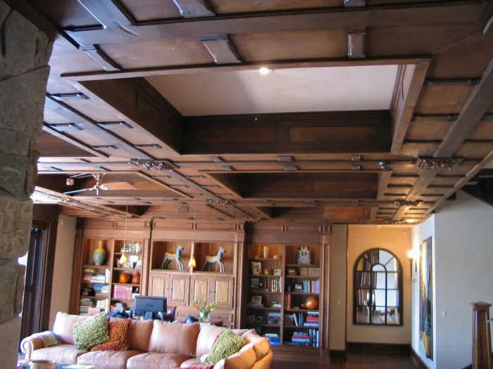 Great room with a custom coffered ceiling, beams, and built-ins