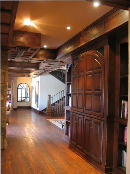 Wood-paneled hallway with custom millwork and an arched window