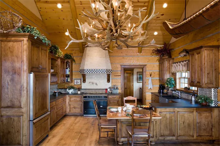 Rustic custom kitchen in knotty alder beneath an antler chandelier