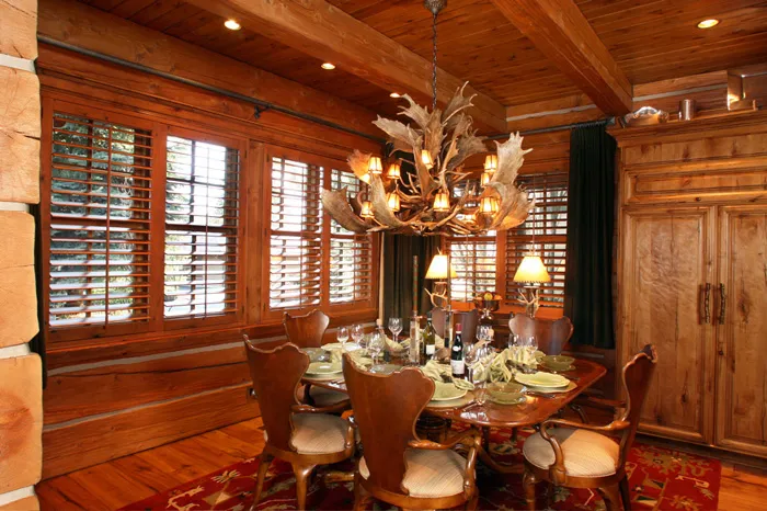 Formal timber-home dining room with custom built-ins and an antler chandelier
